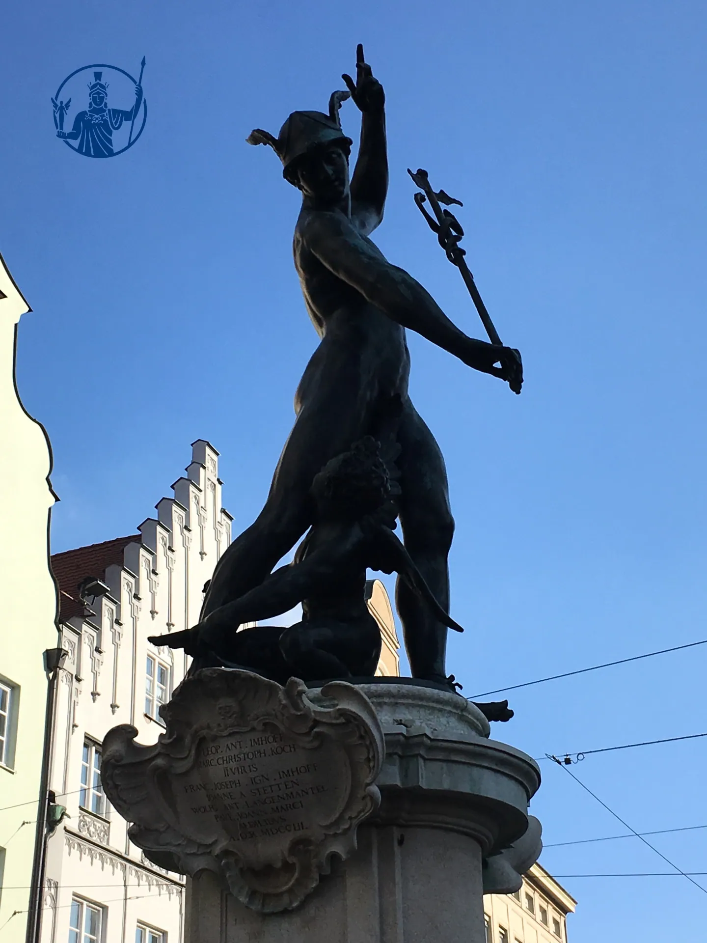 Merkurfigur des Merkurbrunnens vor blauem Himmel