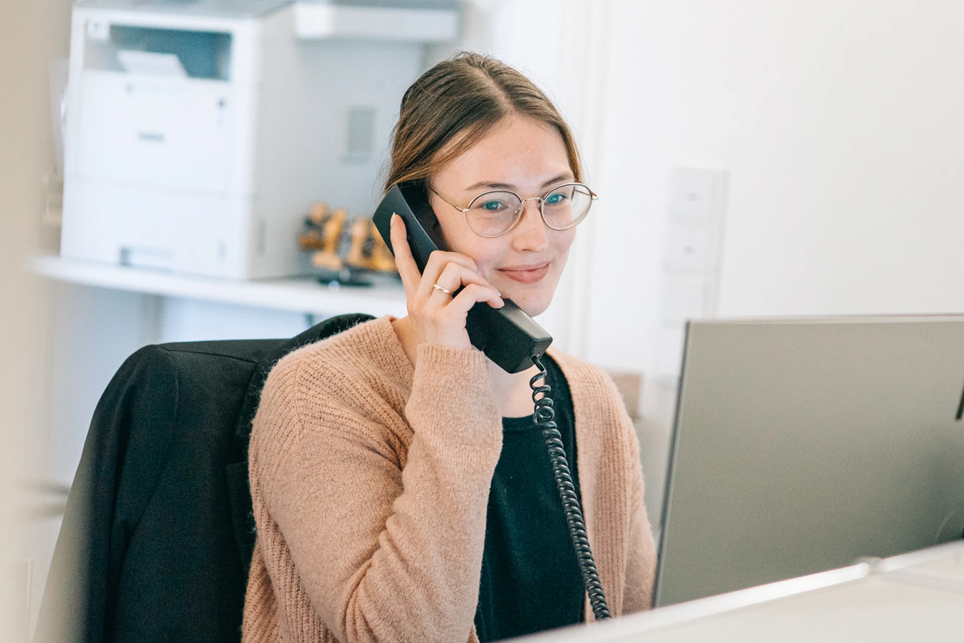 Rechtsanwaltsfachangestellte Anja Ambrosius​ beim Telefonieren am Arbeitsplatz
