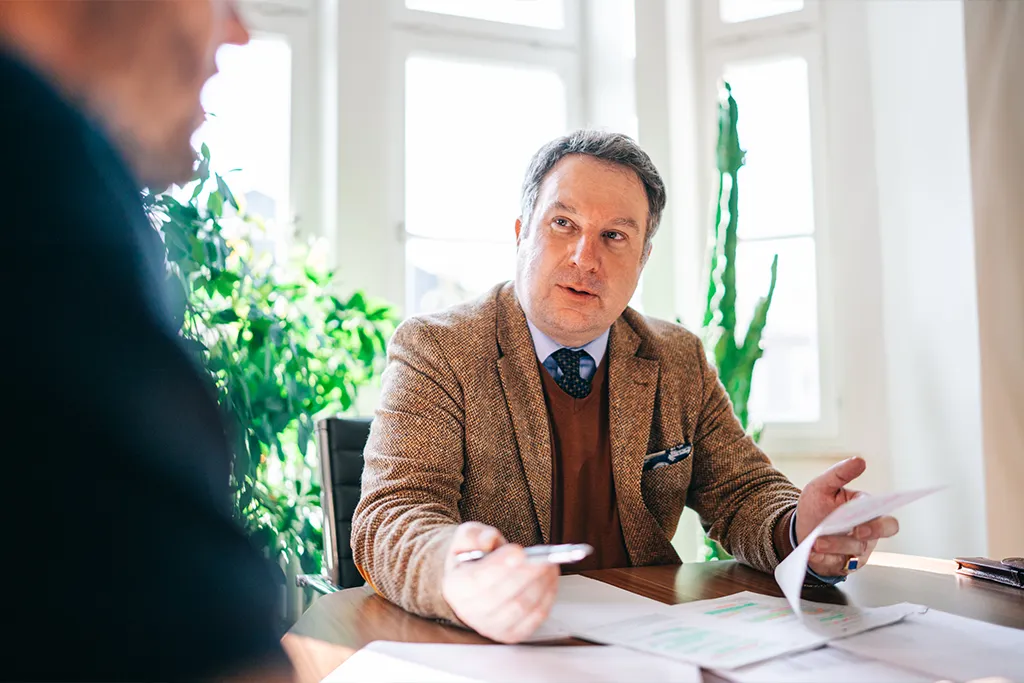 Professor Dr. Peter Kreuz bespricht Unterlagen zum Erbrecht mit Mandant