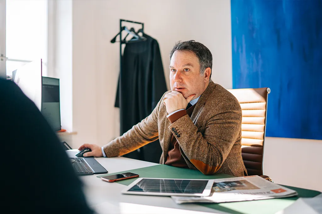 Professor Dr. iur. Peter Kreuz mit konzentriertem Blick im Mandantengespräch in der Kanzlei Augsburg