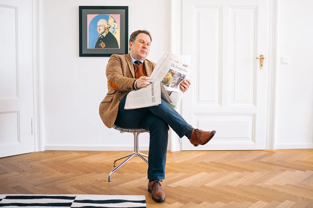 Professor Dr. Peter Kreuz liest Zeitung im Büro der Kanzlei Augsburg